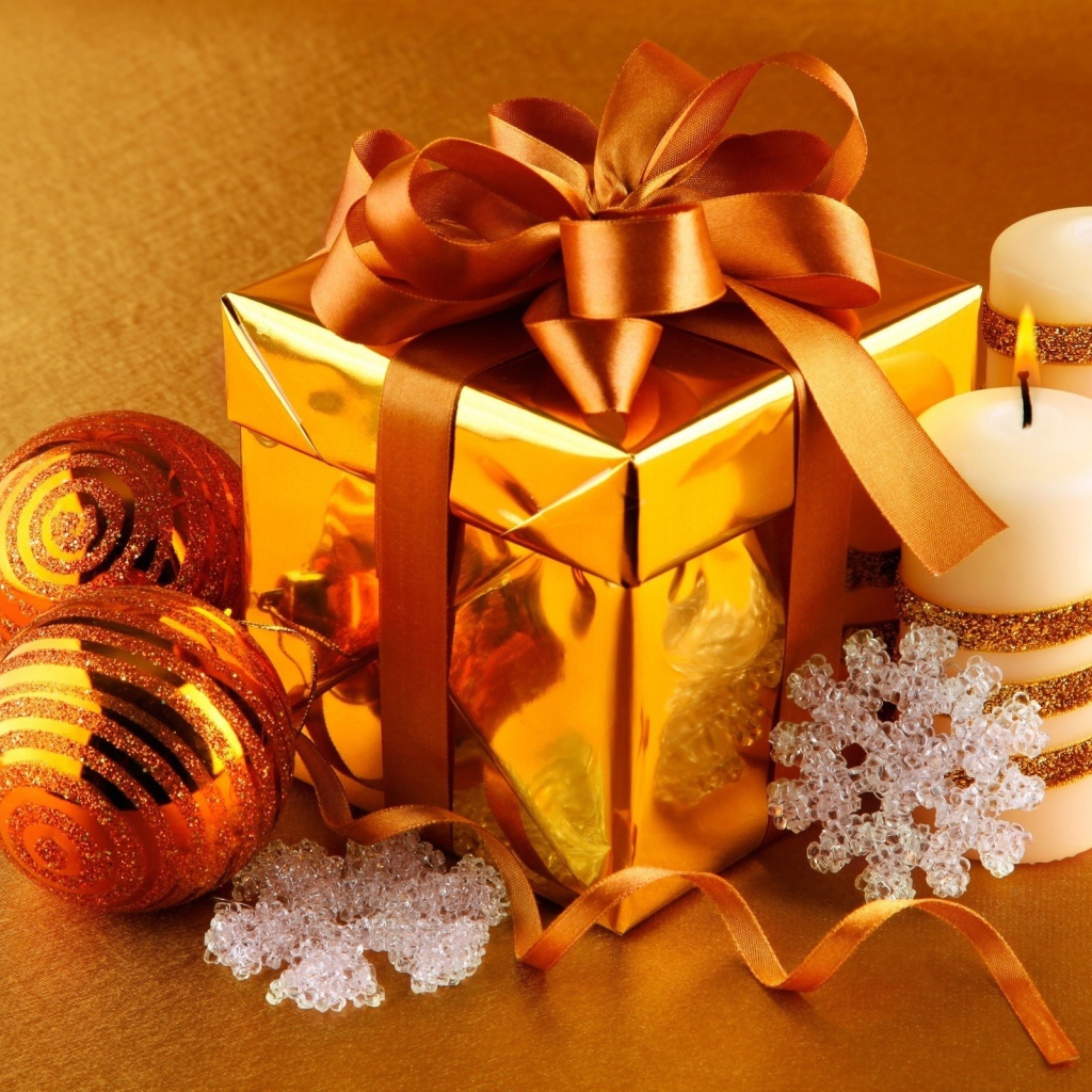 Подарок, елочные шарики и зажженные свечи на новый год 2020 