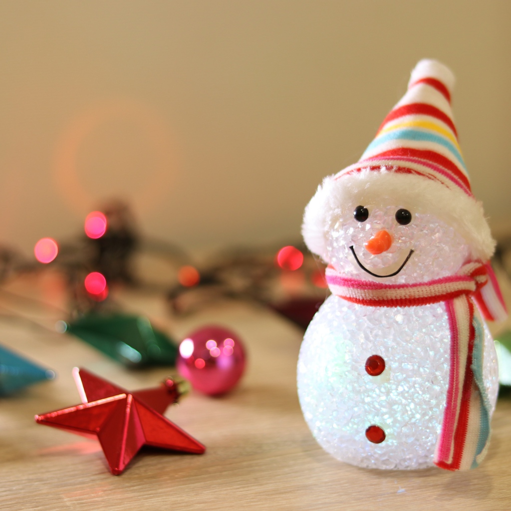 Снеговик с новогодними игрушками на столе