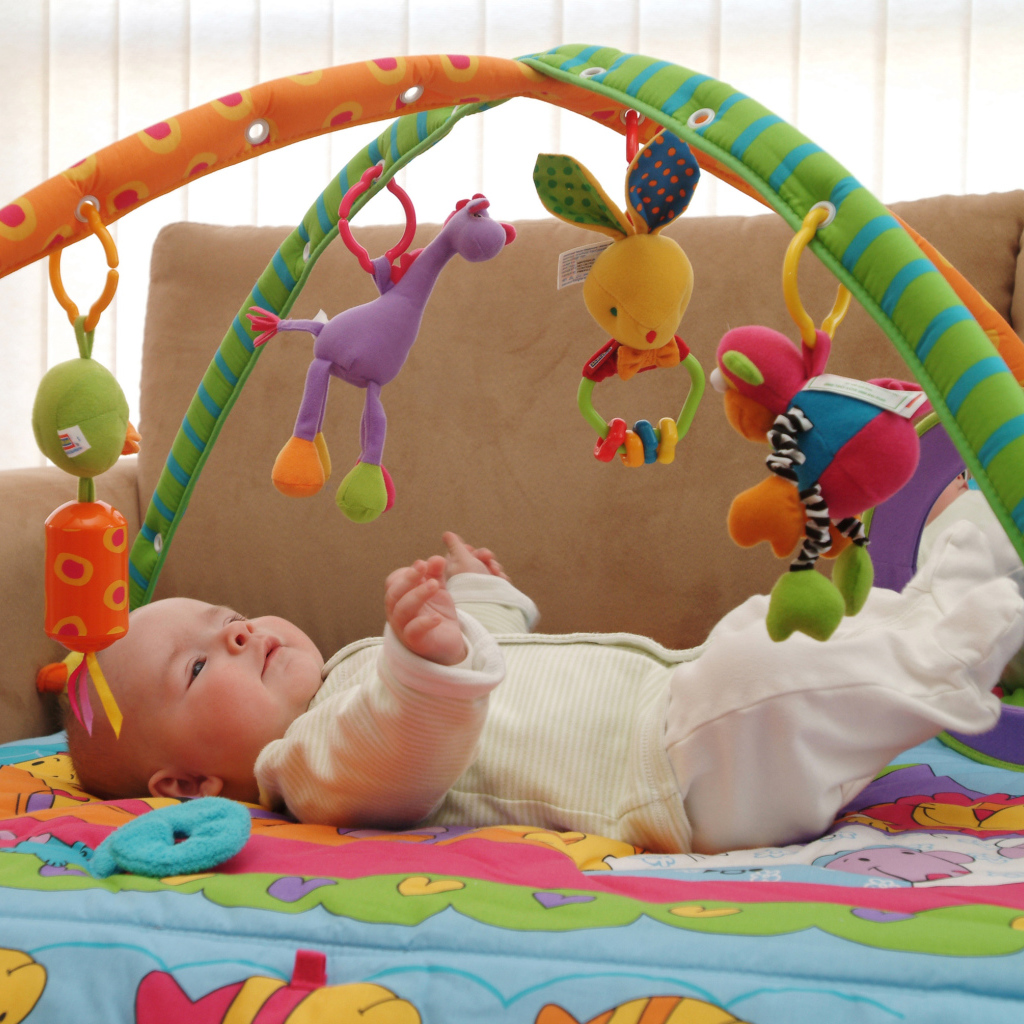 Грудной малыш играет с игрушками