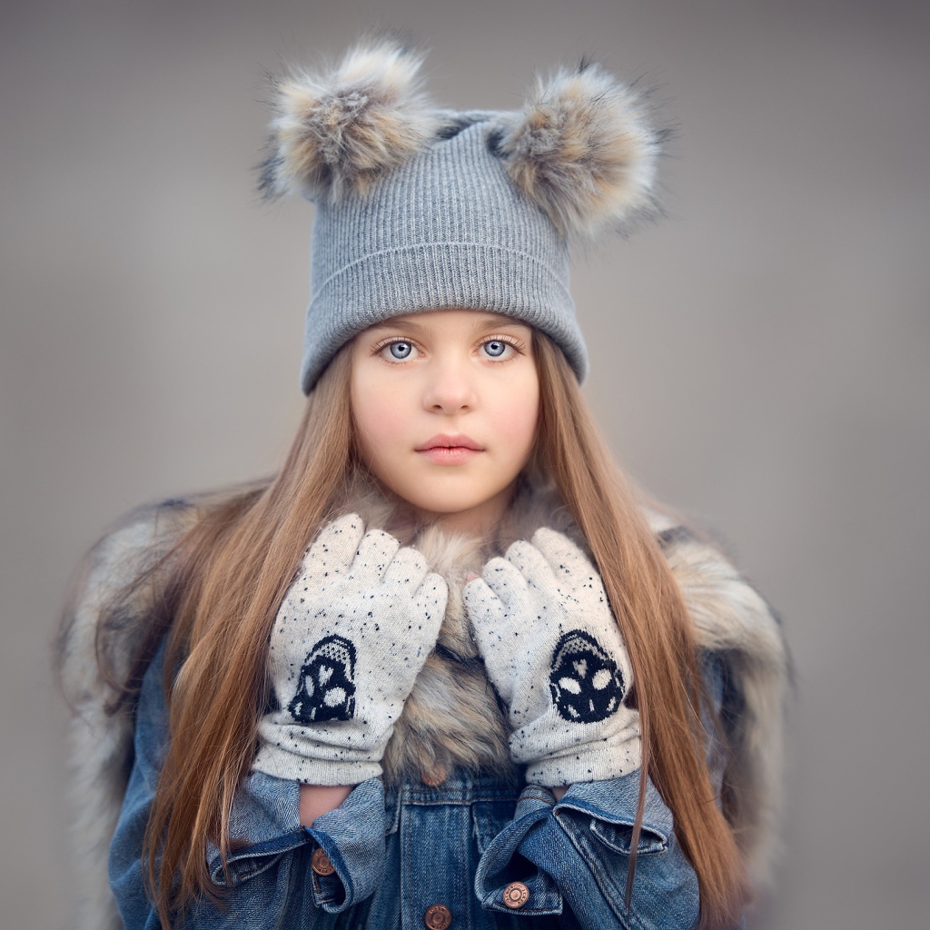 Красивая голубоглазая девочка в теплой шапке