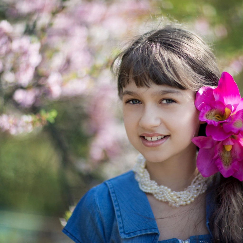 Красивая девочка с розовыми цветами в волосах