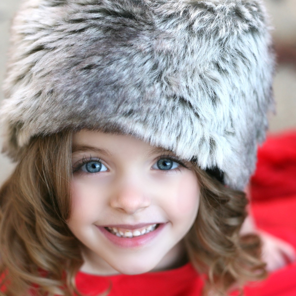 Красивая улыбающаяся девочка в меховой шапке