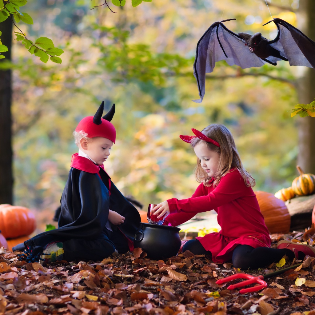 Мальчик и девочка в лесу в костюмах на праздник Хэллоуин 