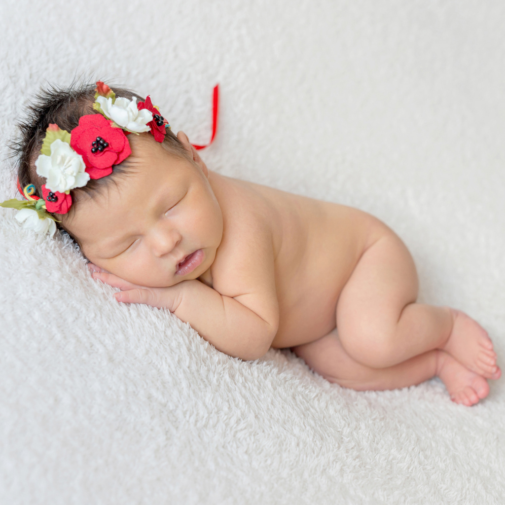 Грудная спящая девочка с венком на голове 