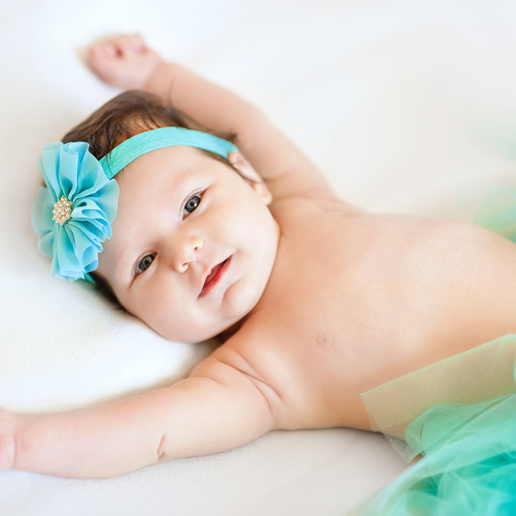 Милая маленькая девочка с повязкой с голубым цветком