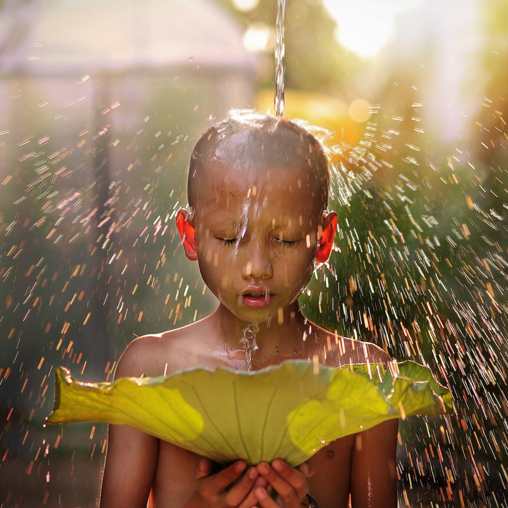 Маленький мальчик азиат умывается водой