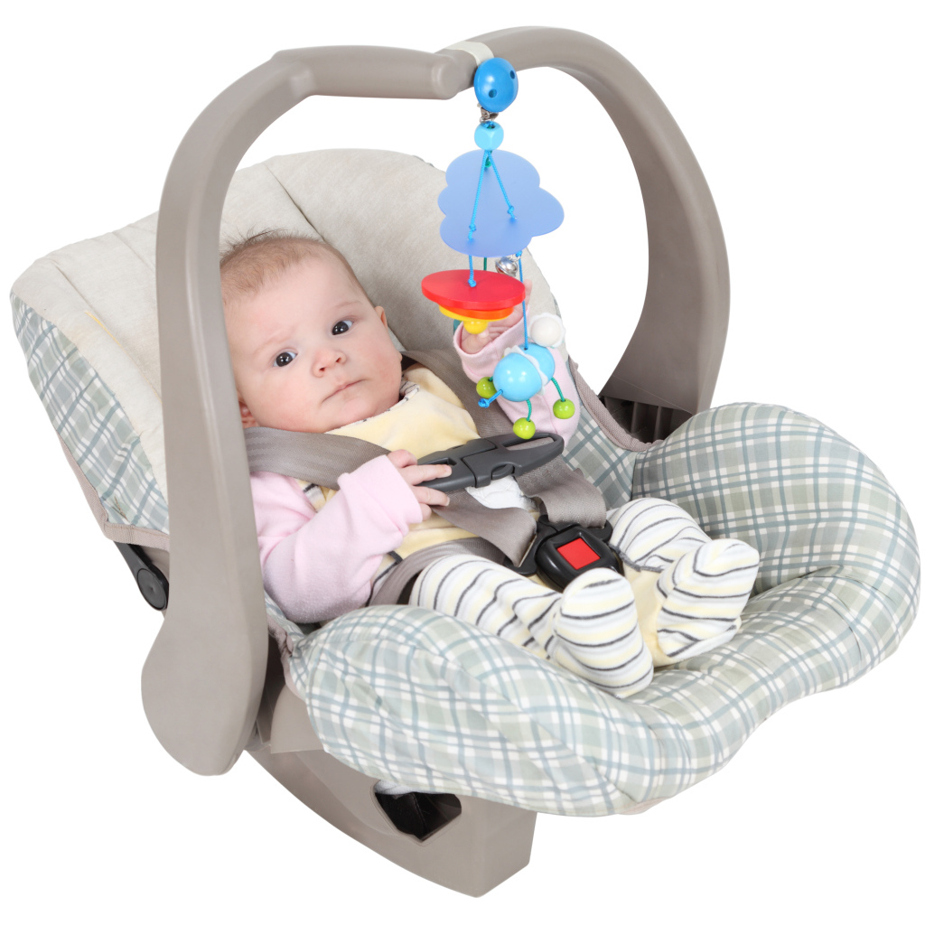 Маленький грудной ребенок в автомобильном кресле на белом фоне