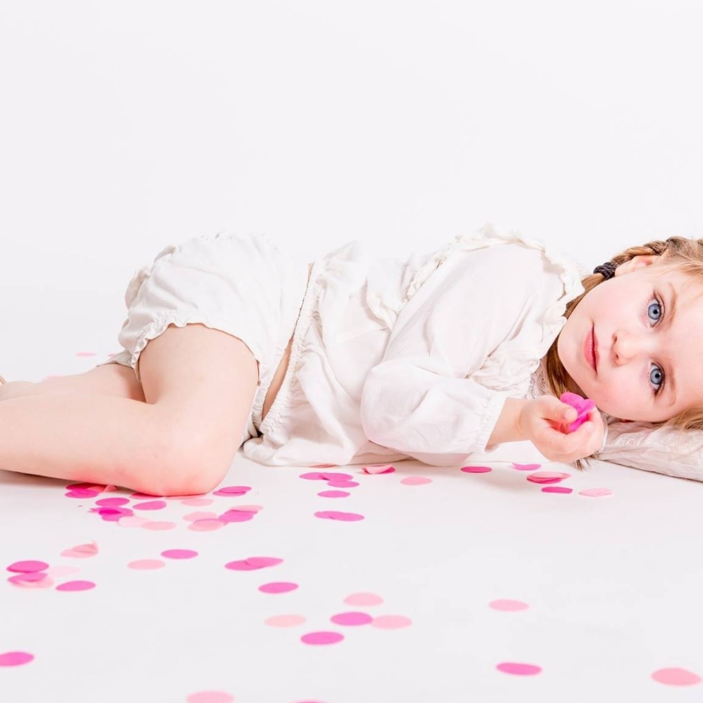 Маленькая голубоглазая девочка лежит на полу