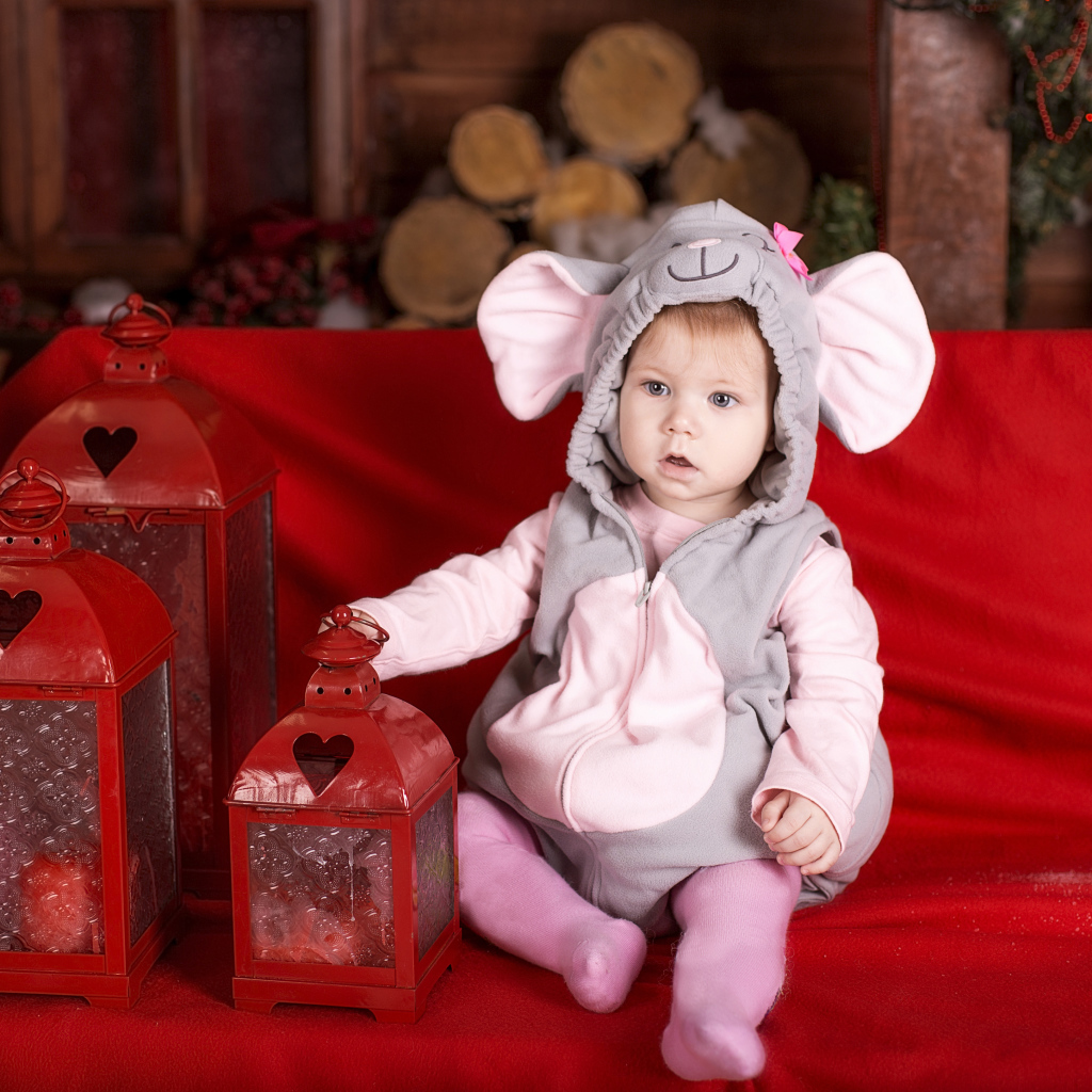 Маленький мальчик в костюме мышонка с фонарями на диване