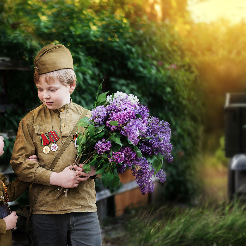 Маленький мальчик с девочкой в военной форме с букетом сирени на 9 мая 