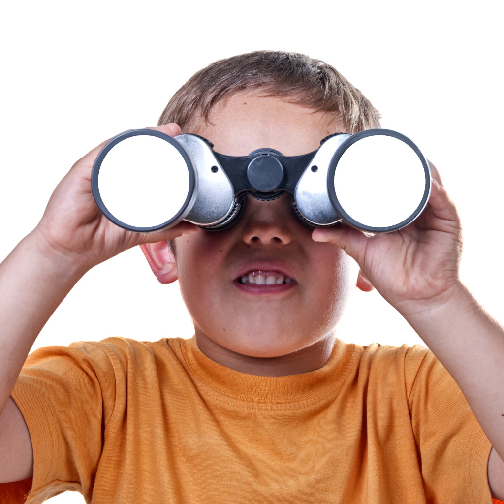 Маленький мальчик с биноклем на белом фоне