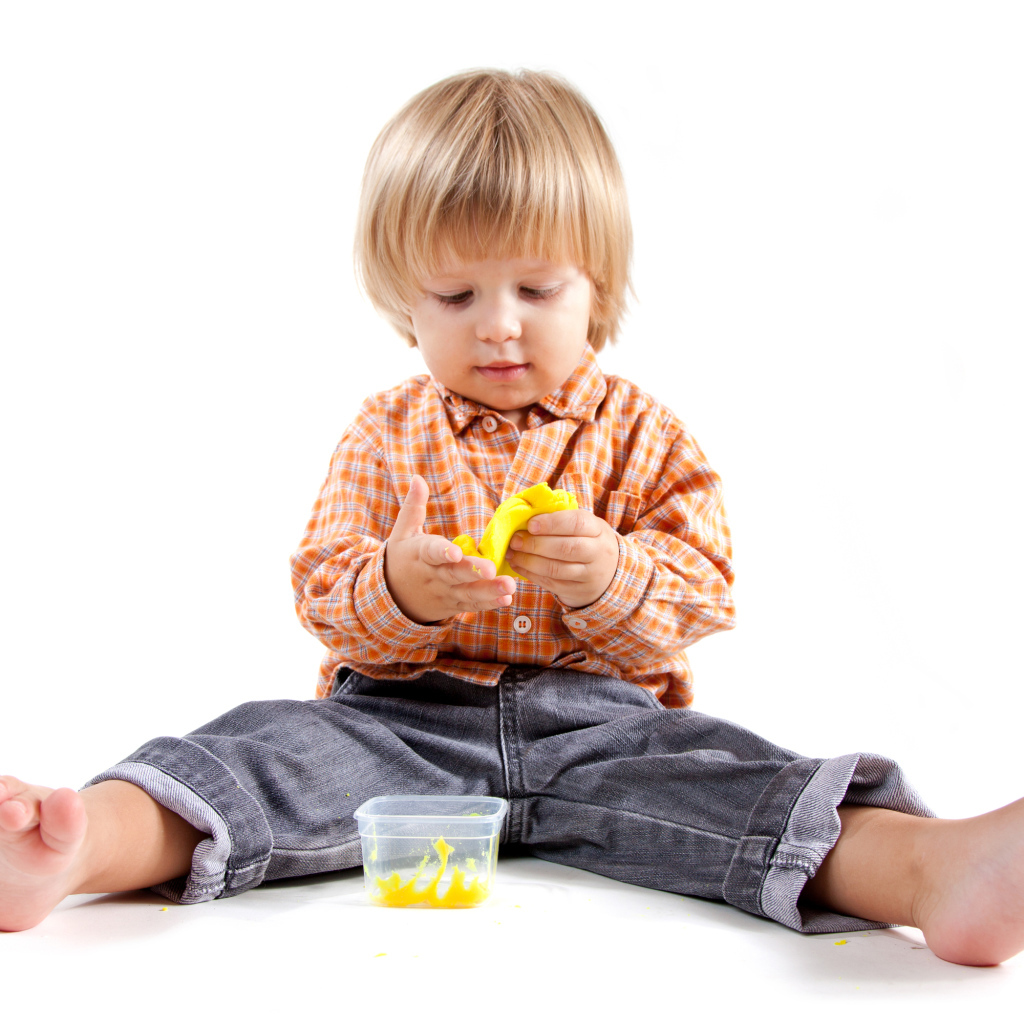 Маленький мальчик с игрушкой на белом фоне