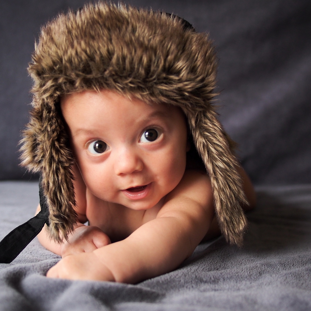 Маленький кареглазый ребенок в теплой шапке