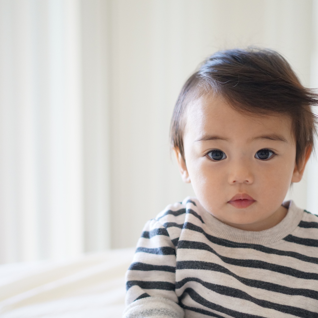 Маленький кареглазый мальчик в полосатом свитере