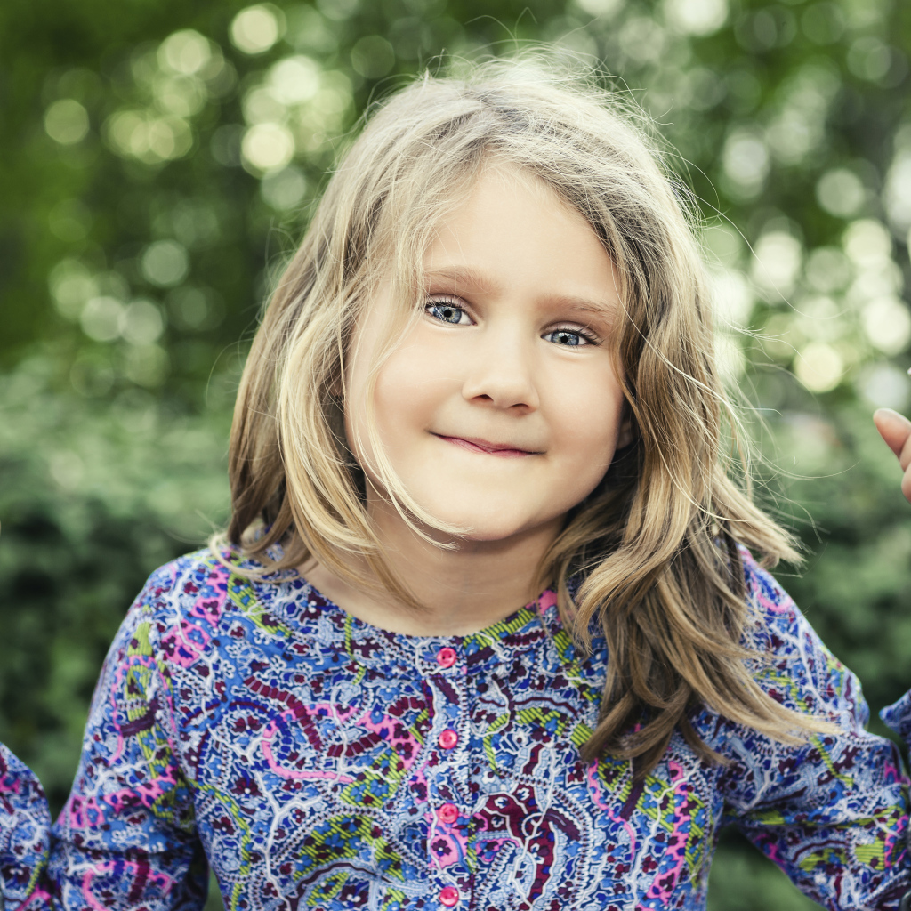 Маленькая милая голубоглазая девочка на качели