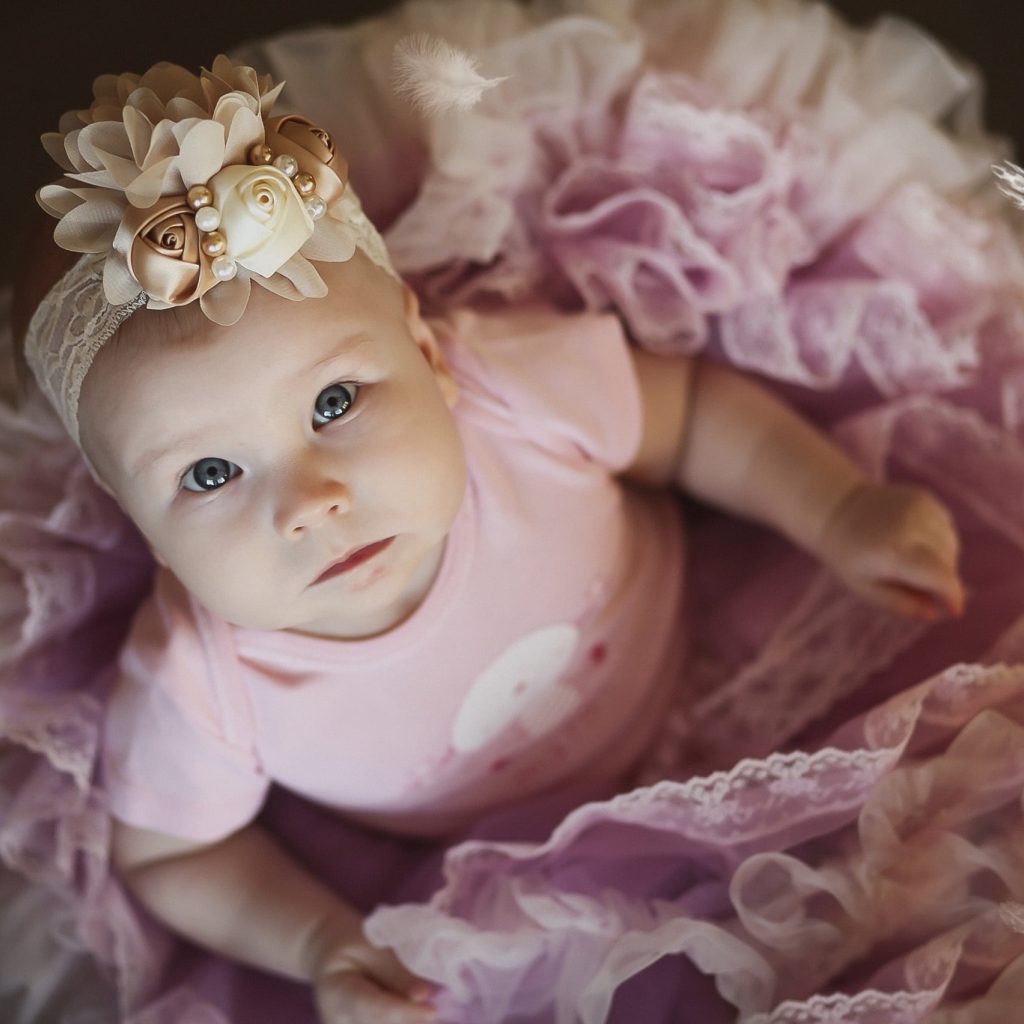 Маленькая милая девочка в пышном платье с повязкой на голове