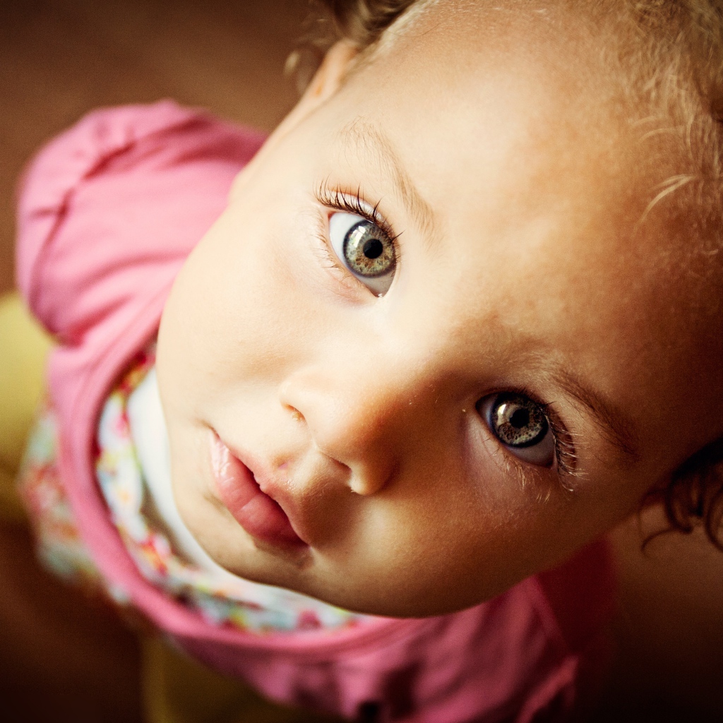 Маленькая девочка крупным планом смотрит вверх 