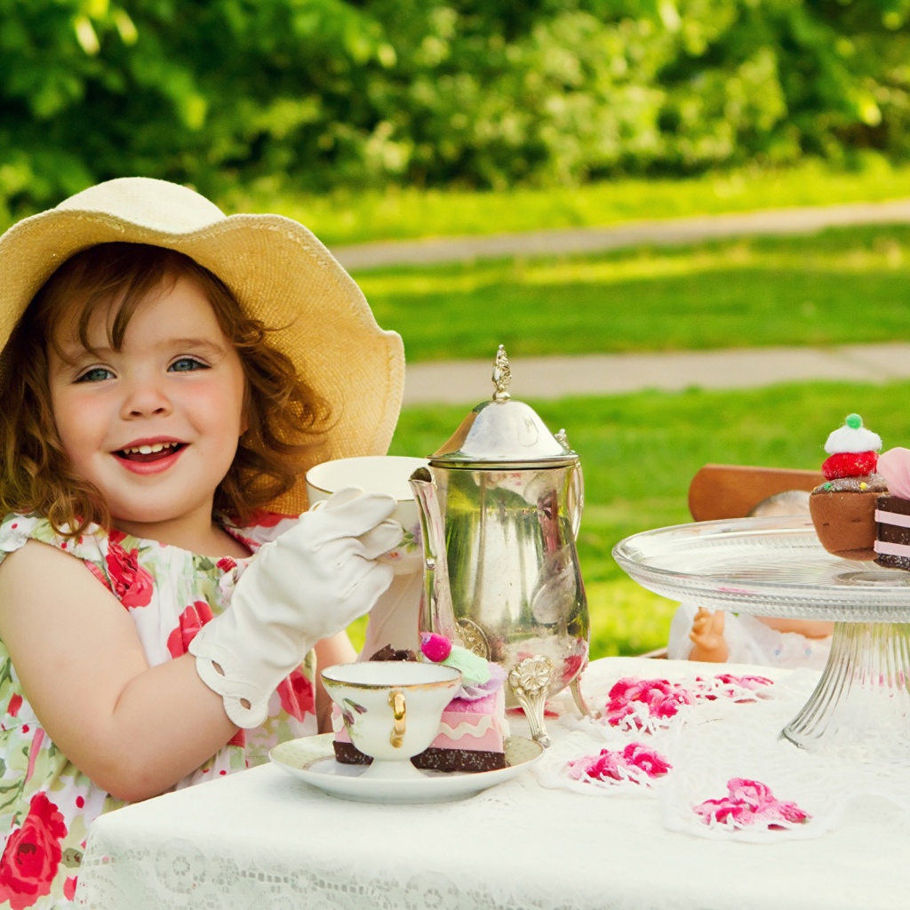 Маленькая девочка пьет чай на природе