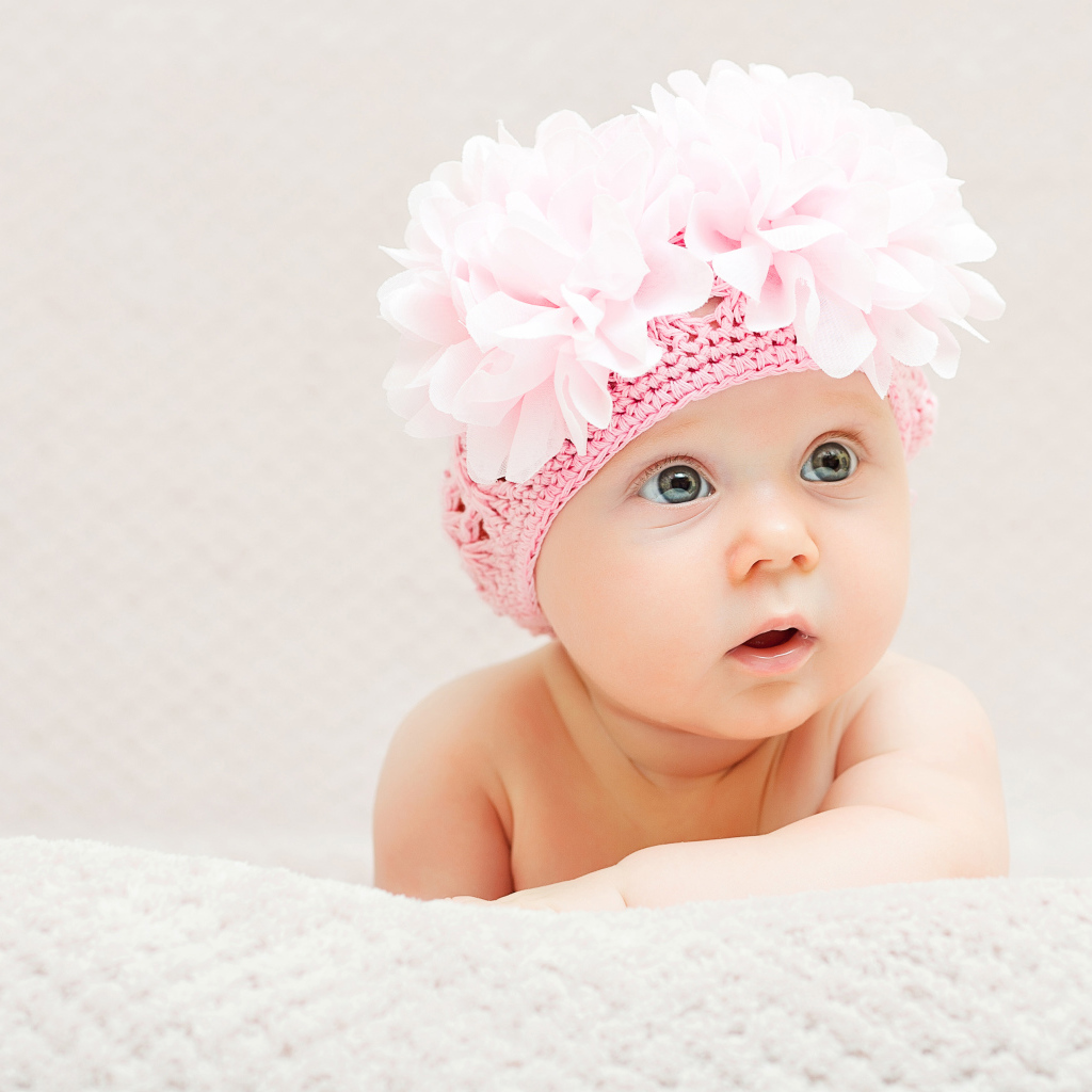 Маленькая девочка в вязаной шапке с цветами