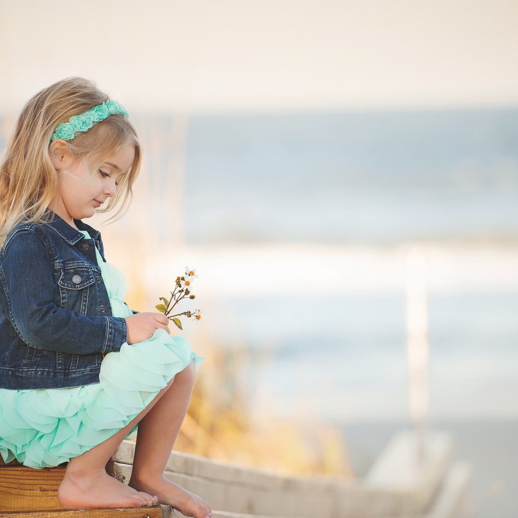 Маленькая девочка сидит на мосту