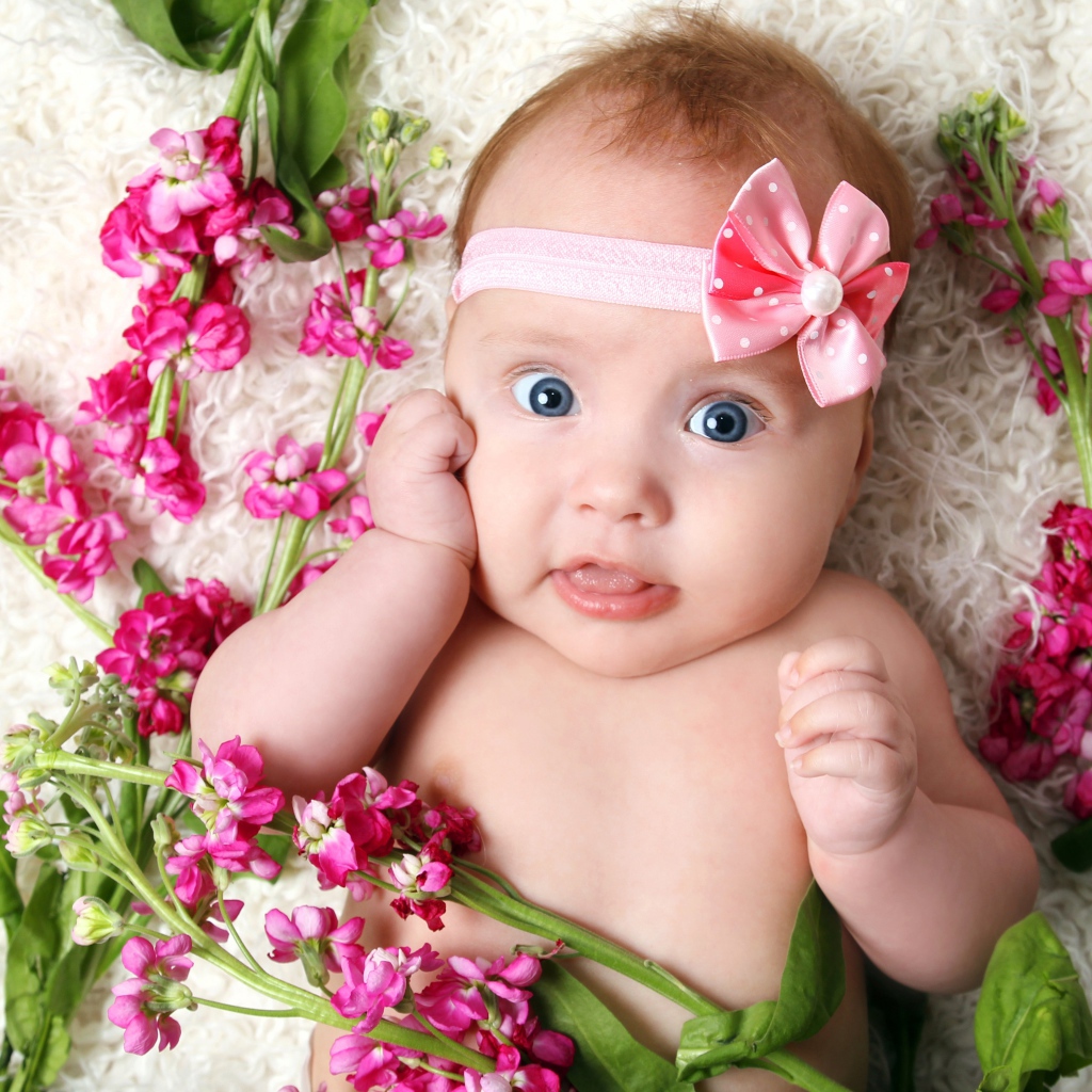 Маленькая девочка с повязкой лежит с розовыми цветами