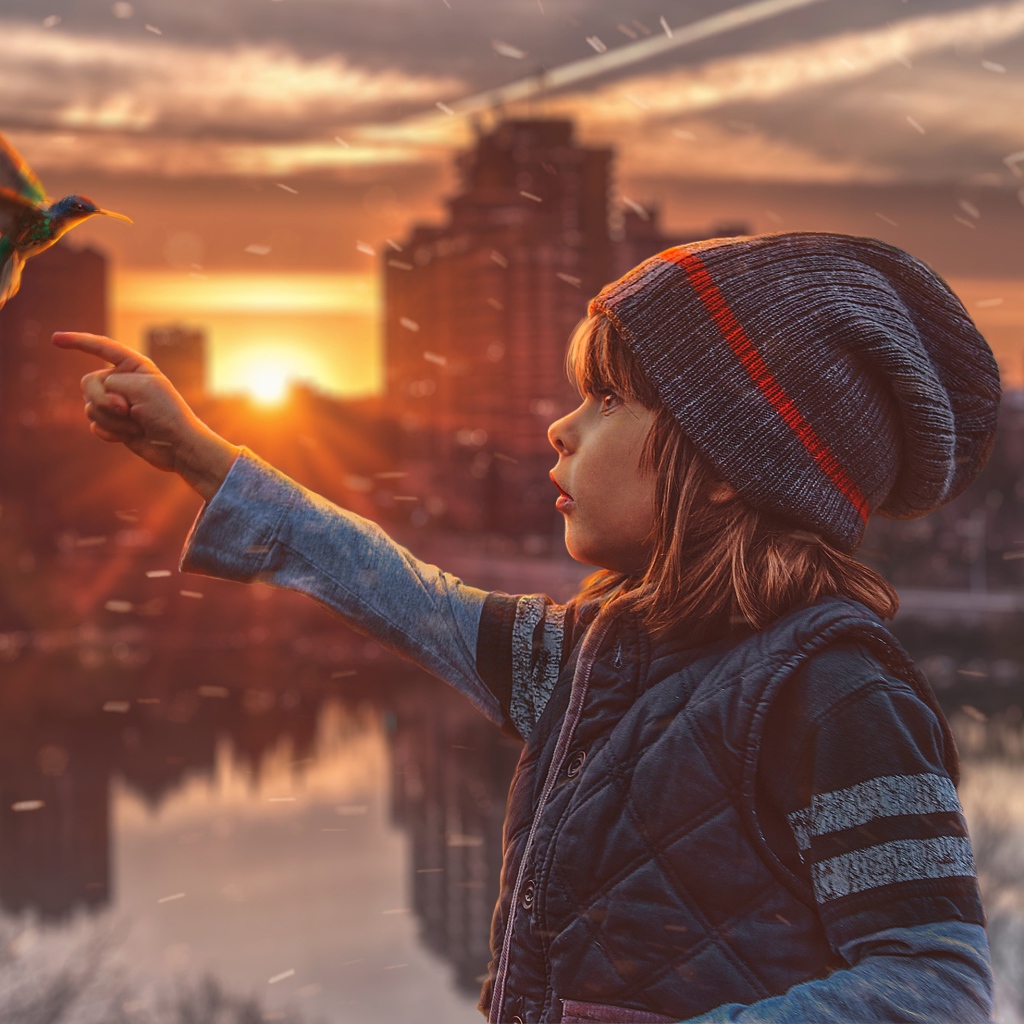 Маленькая девочка с птицей колибри на фоне города