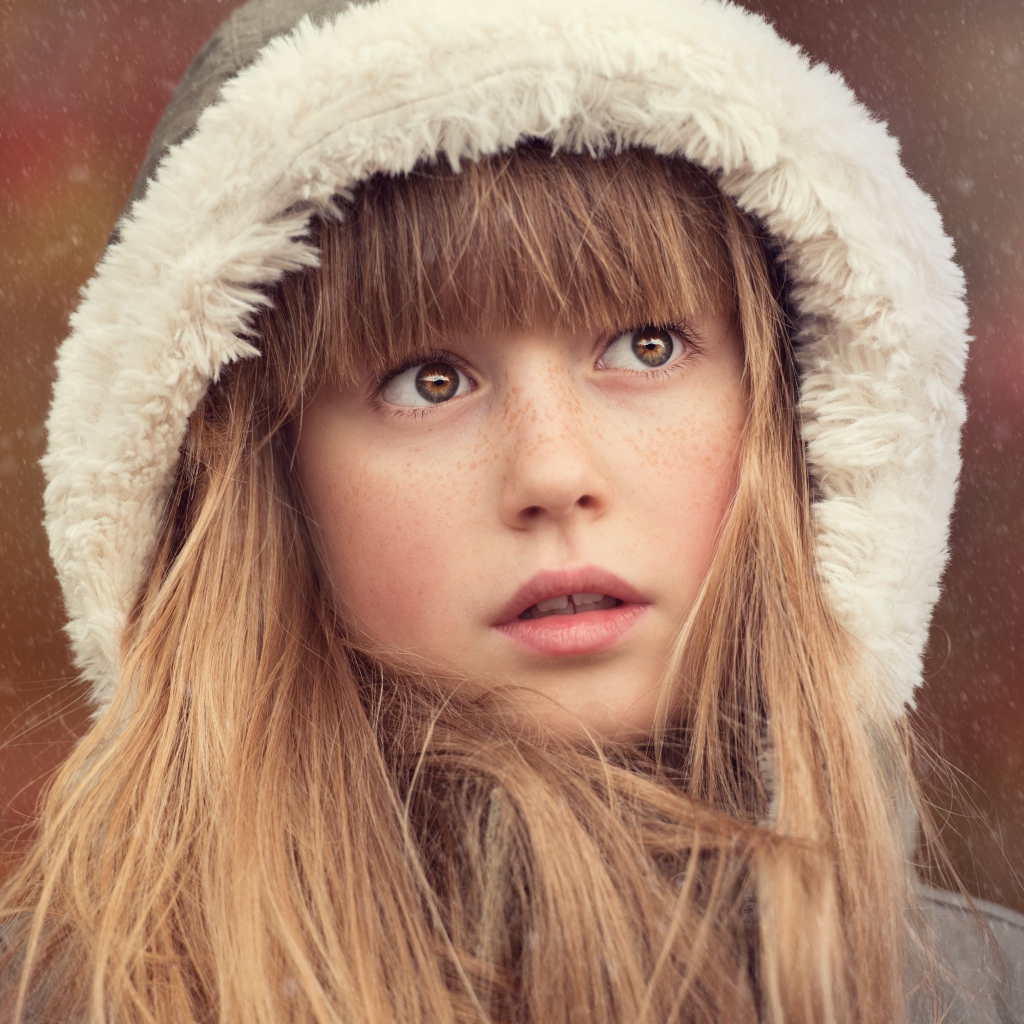 Маленькая девочка с веснушками на лице в капюшоне 