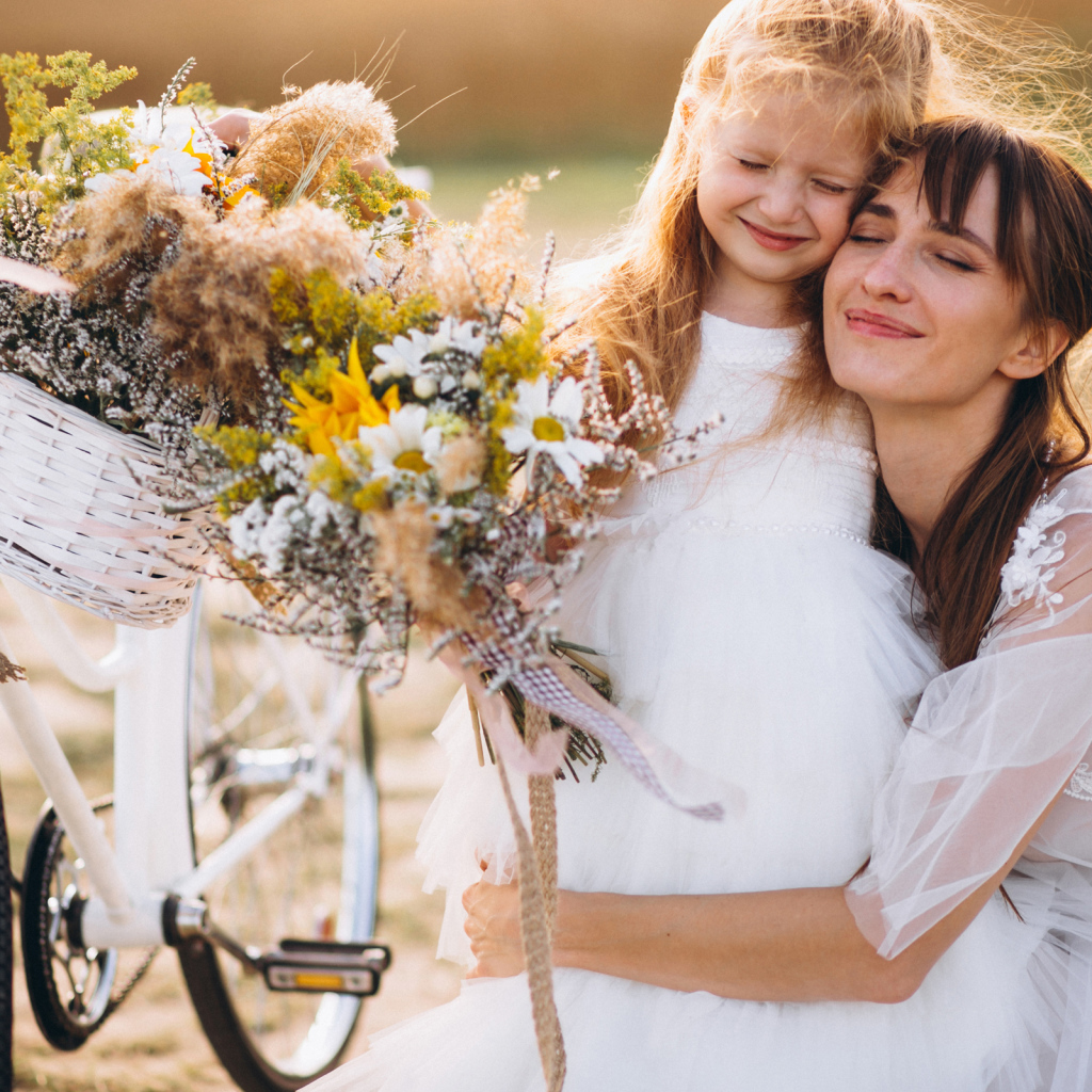 Маленькая девочка с мамой у велосипеда