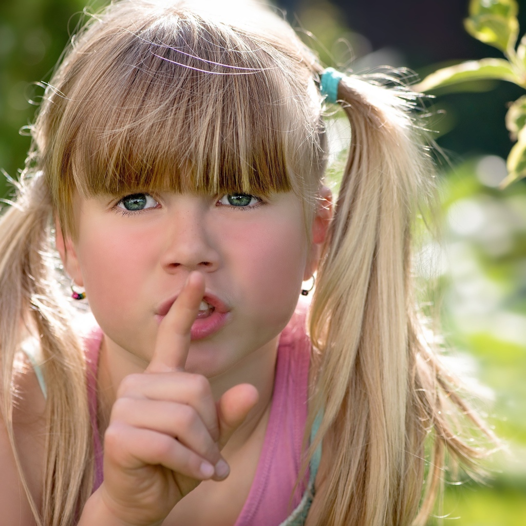 Маленькая зеленоглазая девочка с пальцем у рта 