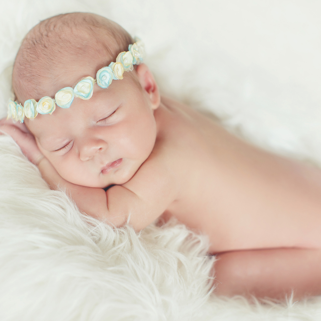 Маленький спящий ребенок на меховом покрывале