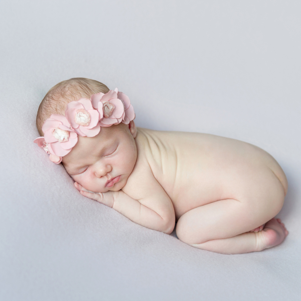 Спящая девочка с розовым венком на голове