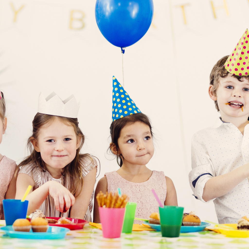 Маленькие дети отмечают детский праздник за столом