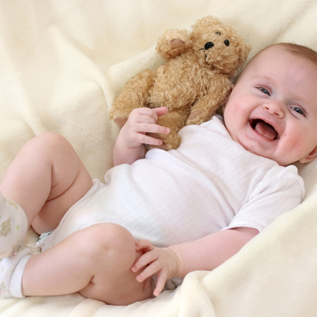 Улыбающийся малыш с медвежонком Тедди 