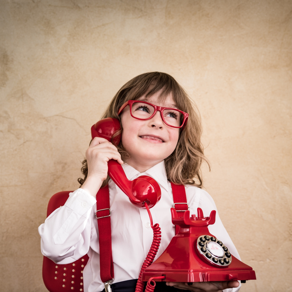 Улыбающийся мальчик с красным телефоном