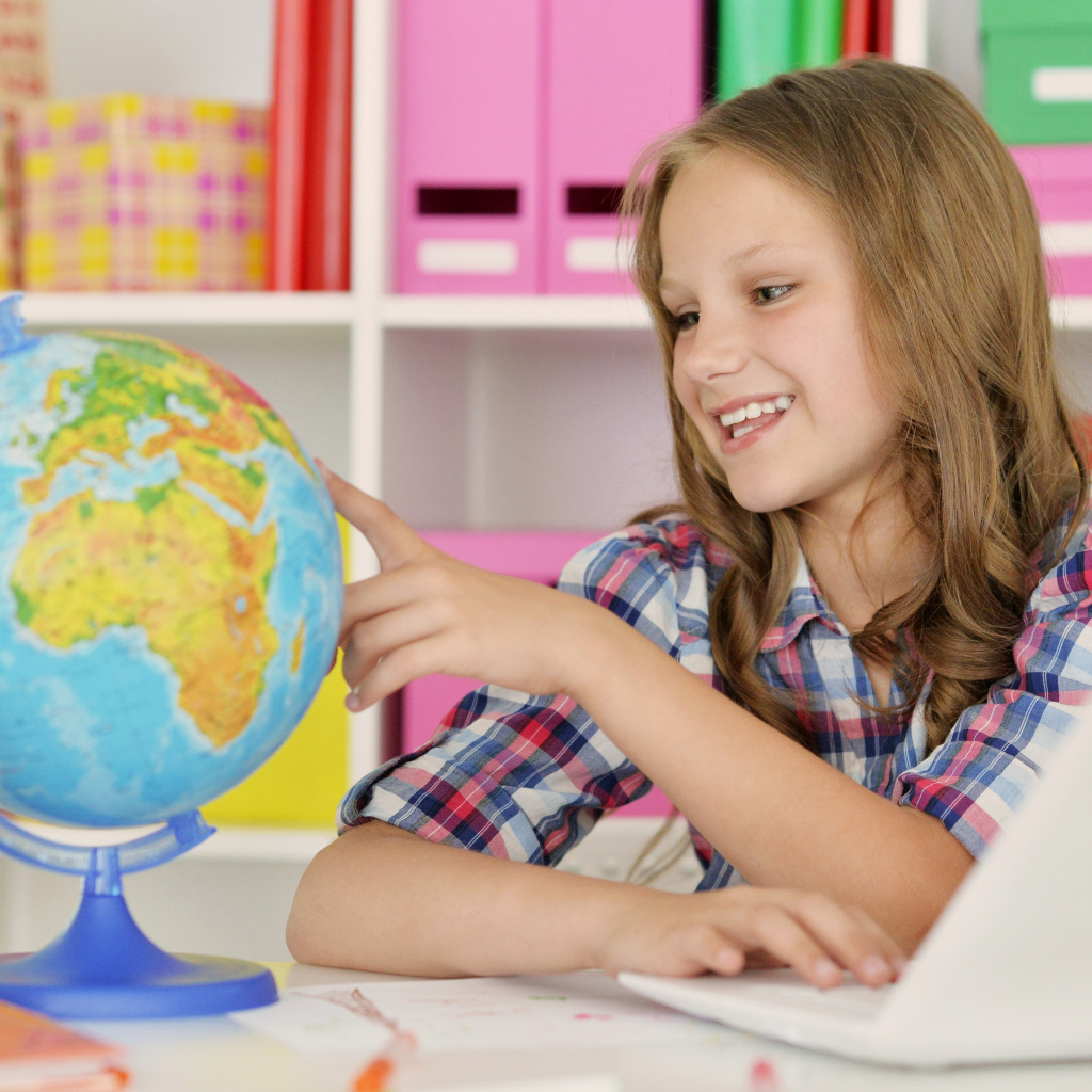 Улыбающаяся девочка школьница с глобусом