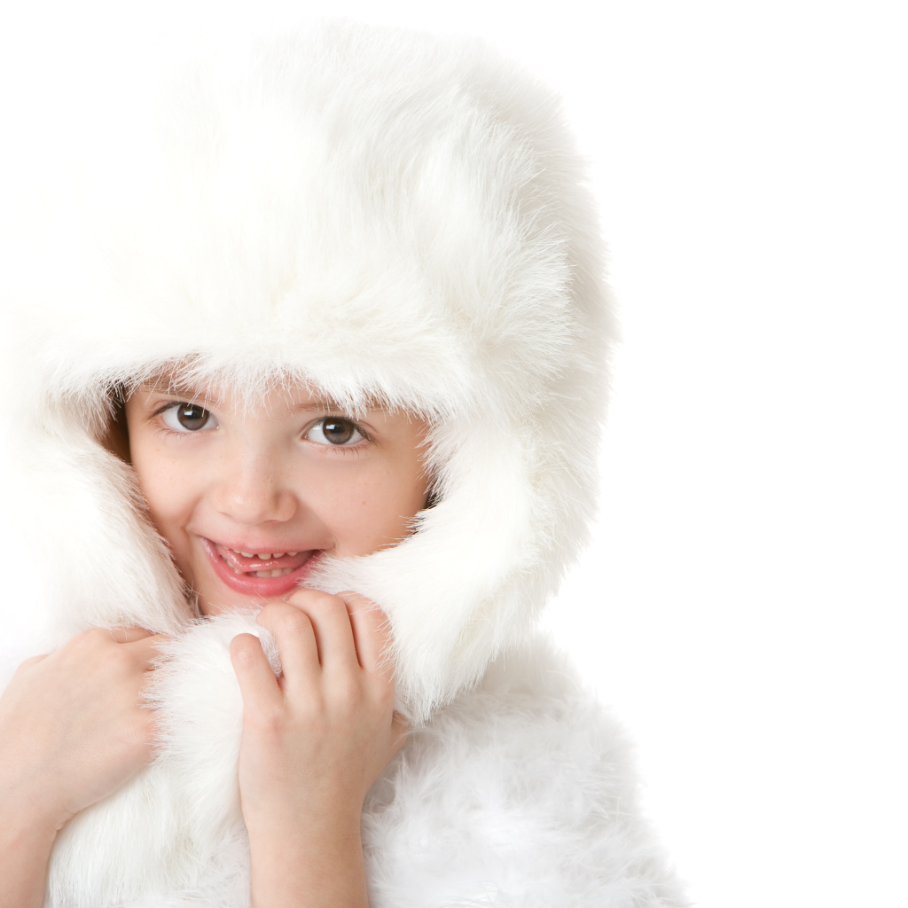 Улыбающаяся маленькая девочка в белой меховой шапке