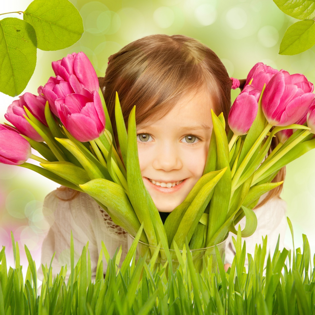 Улыбающаяся маленькая девочка с розовыми тюльпанами
