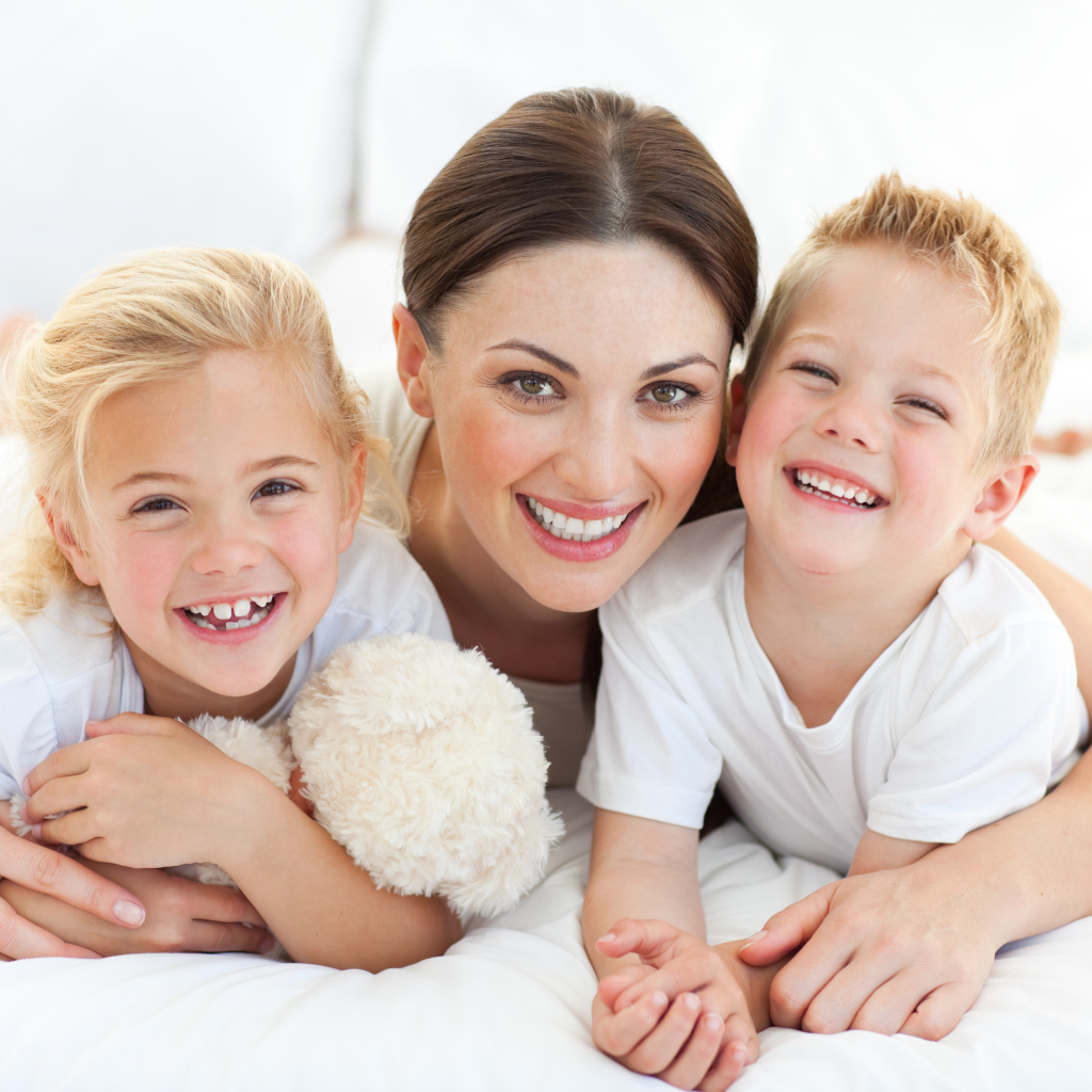Улыбающаяся мама с двумя детьми