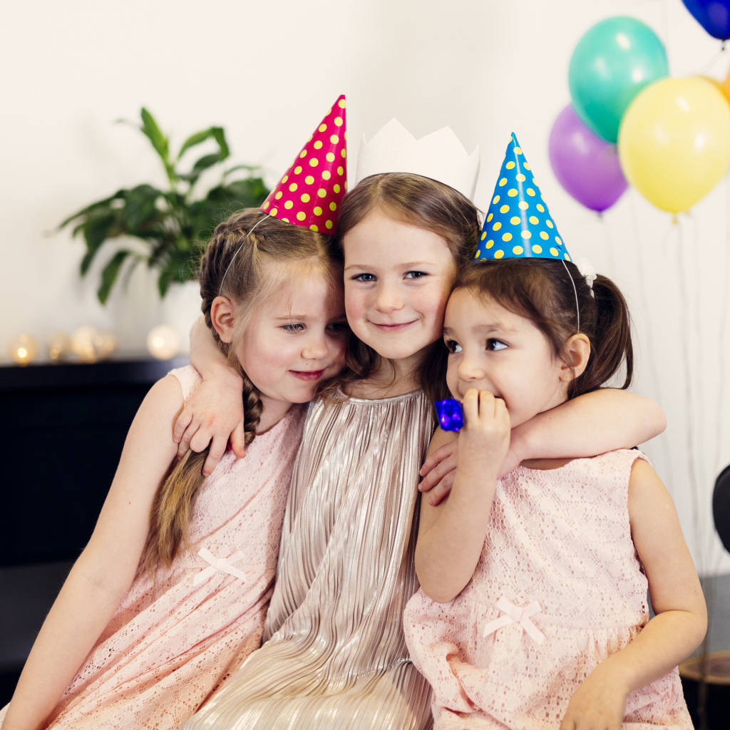 Три маленькие девочки в праздничных колпаках