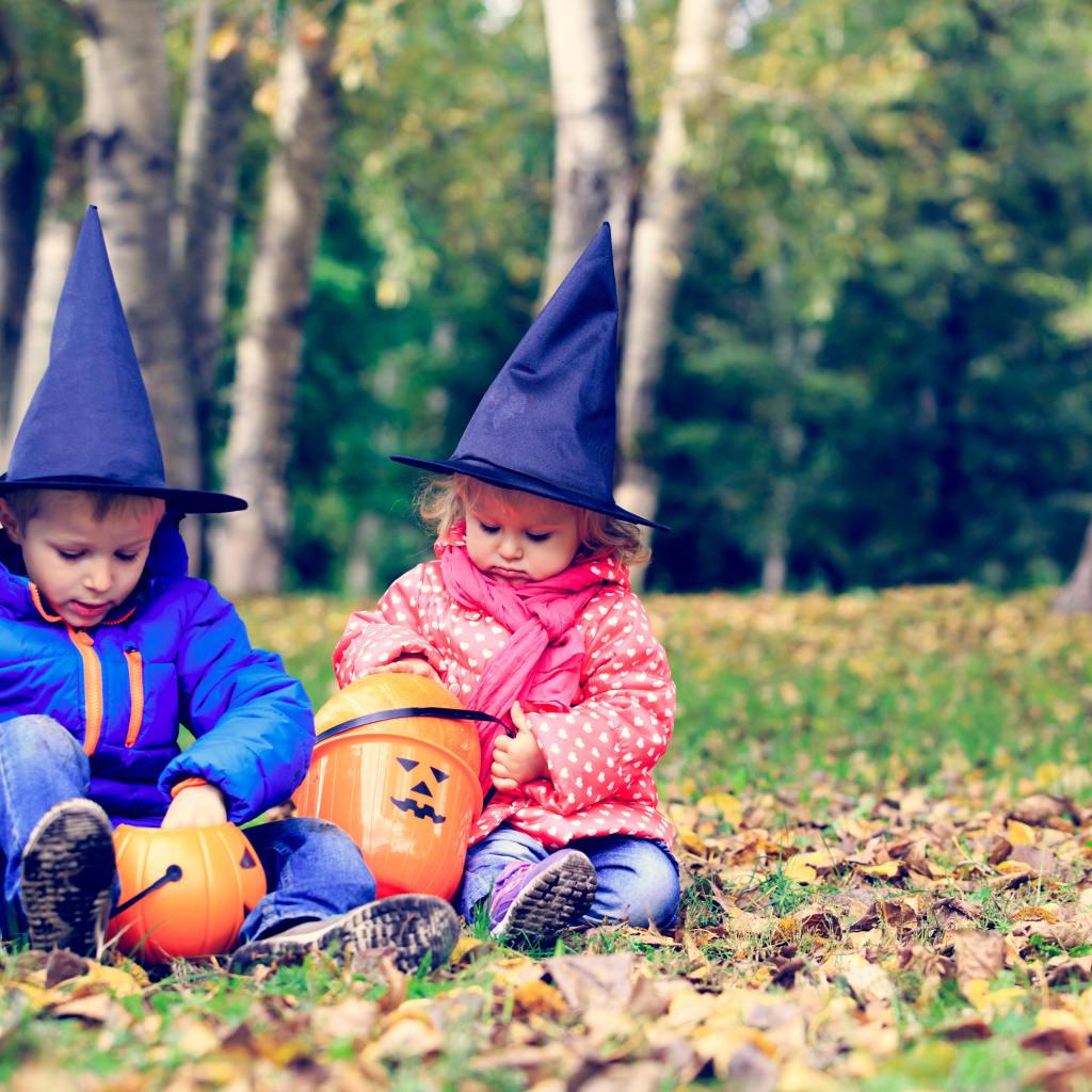 Маленькие мальчик и девочка в лесу на Хэллоуин 