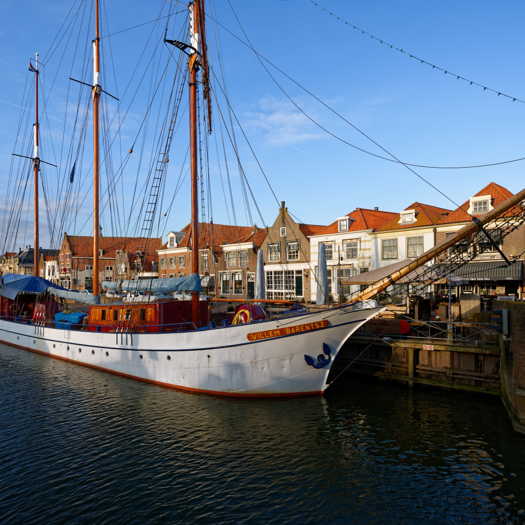 Парусное судно Willem Barentsz с опущенными парусами на причале у домов