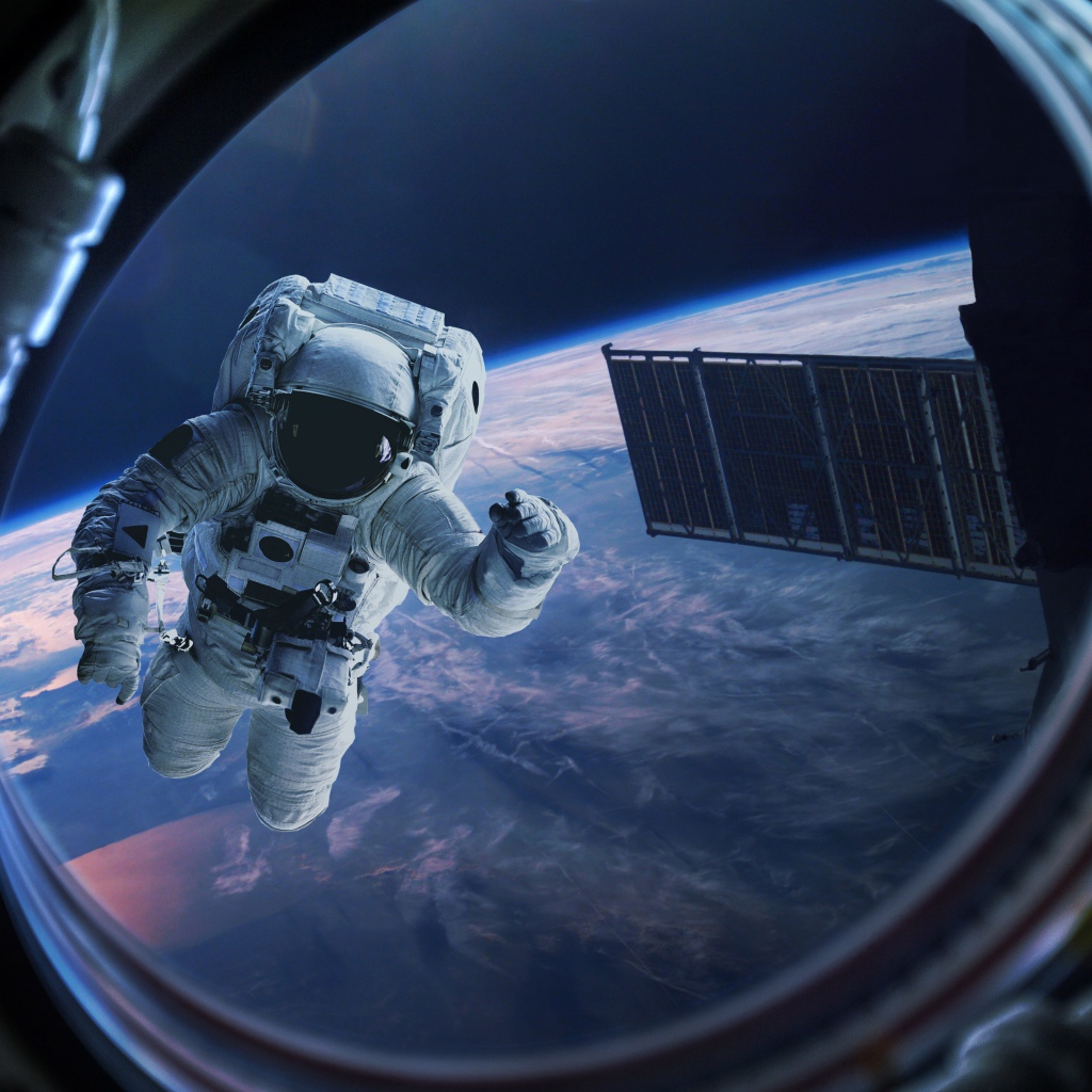 Астронавт в иллюминаторе в космосе