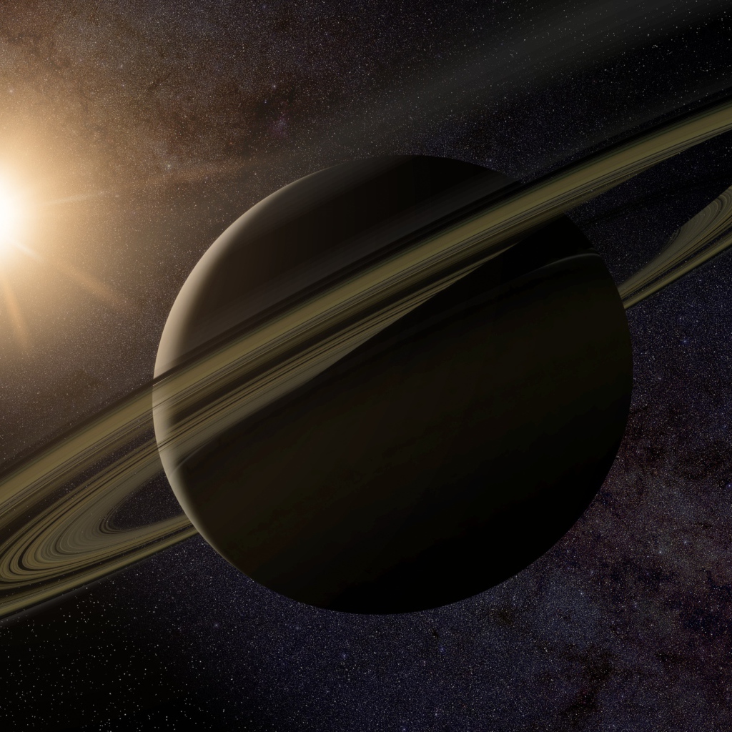 Планета Сатурн с кольцами на фоне солнца