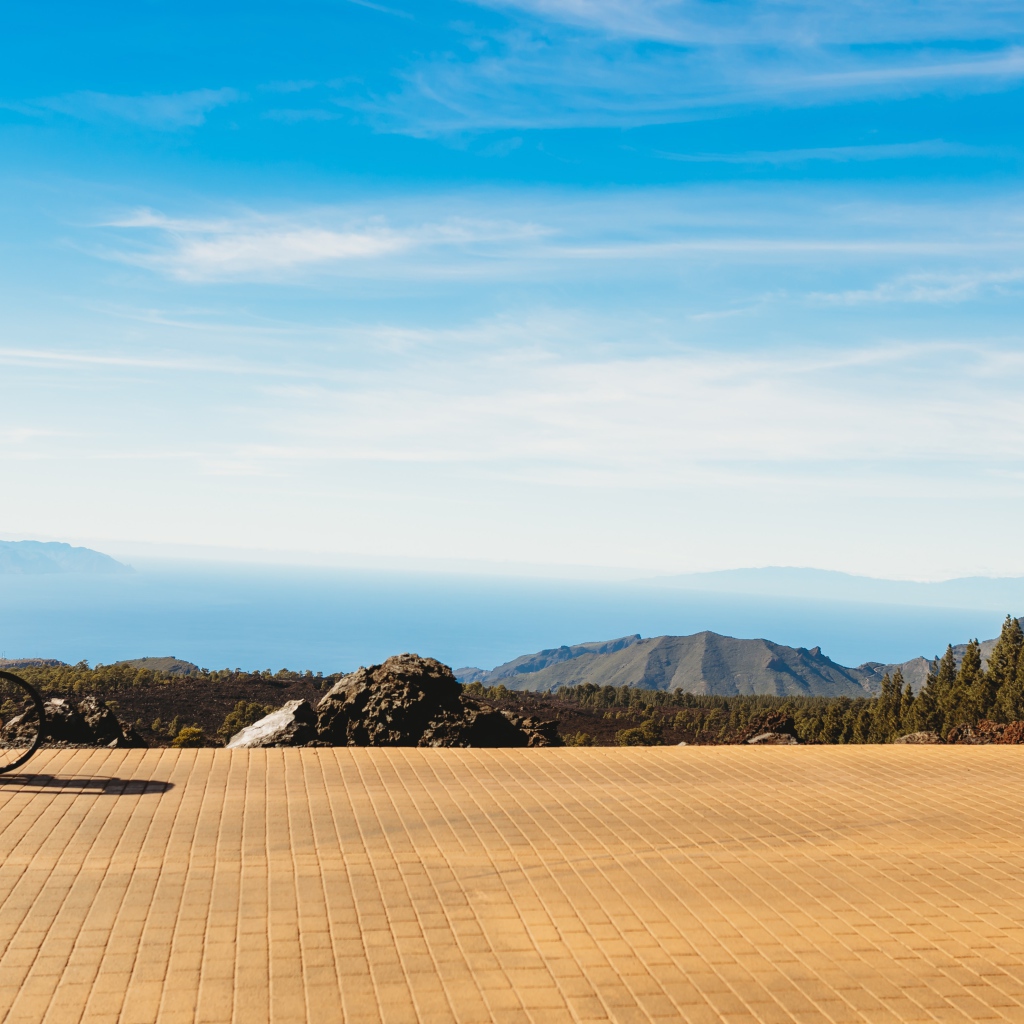 Велосипедист едет по дороге на фоне голубого неба