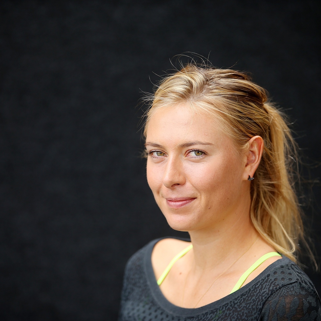 Улыбающаяся блондинка, теннисистка Мария Шарапова на сером фоне