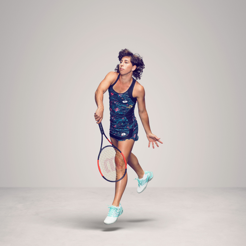 Испанская теннисистка Карла Суарес Наварро с ракеткой на сером фоне