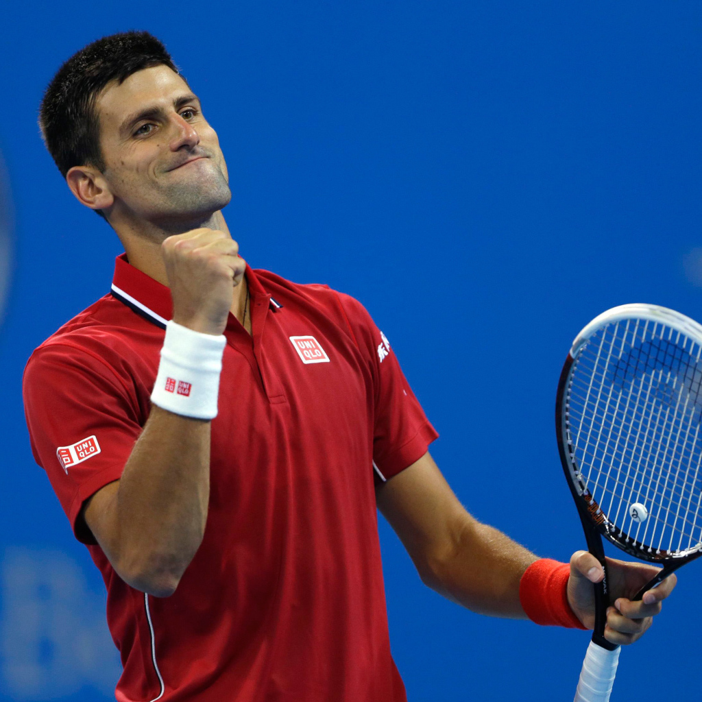 Теннисист Новак Джокович с ракеткой радуется на корте