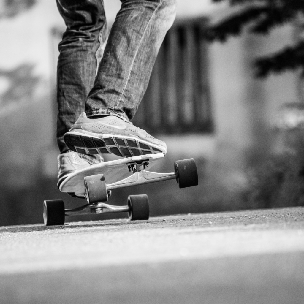 Парень катается на скейтборде по асфальту