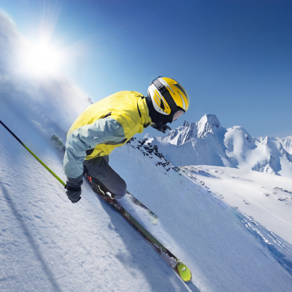 Лыжник в шлеме  спускается по заснеженному склону