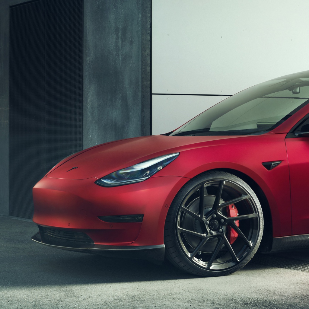 Красный автомобиль Tesla Model 3 2019 года выезжает в гаража